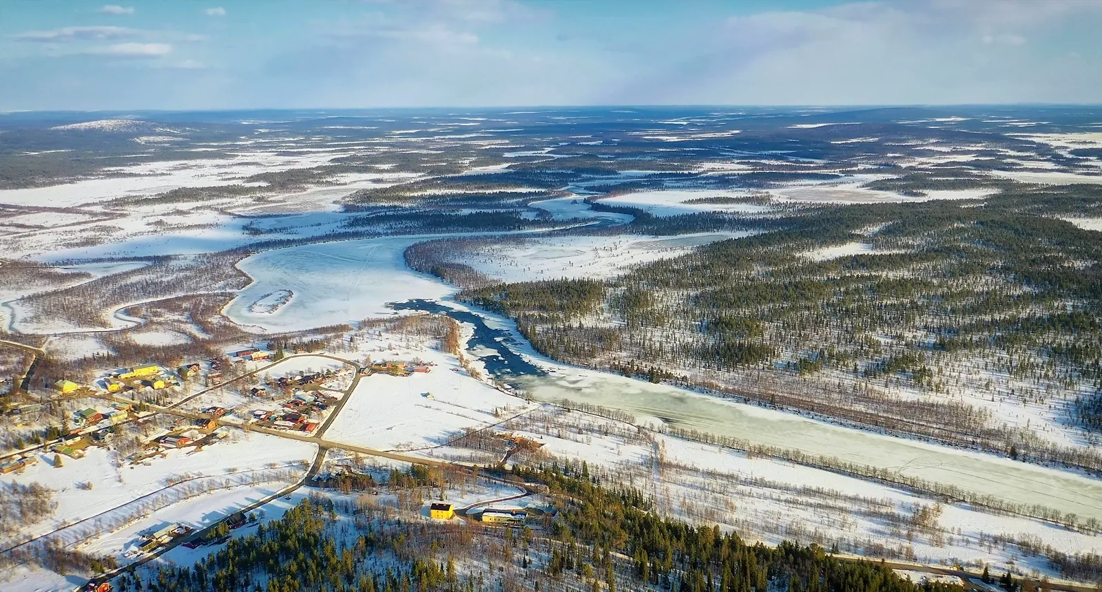 View from ÁILU Hotel overlooking the Lainio River and forested hills of Lannavaara, near Kiruna in Swedish Lapland